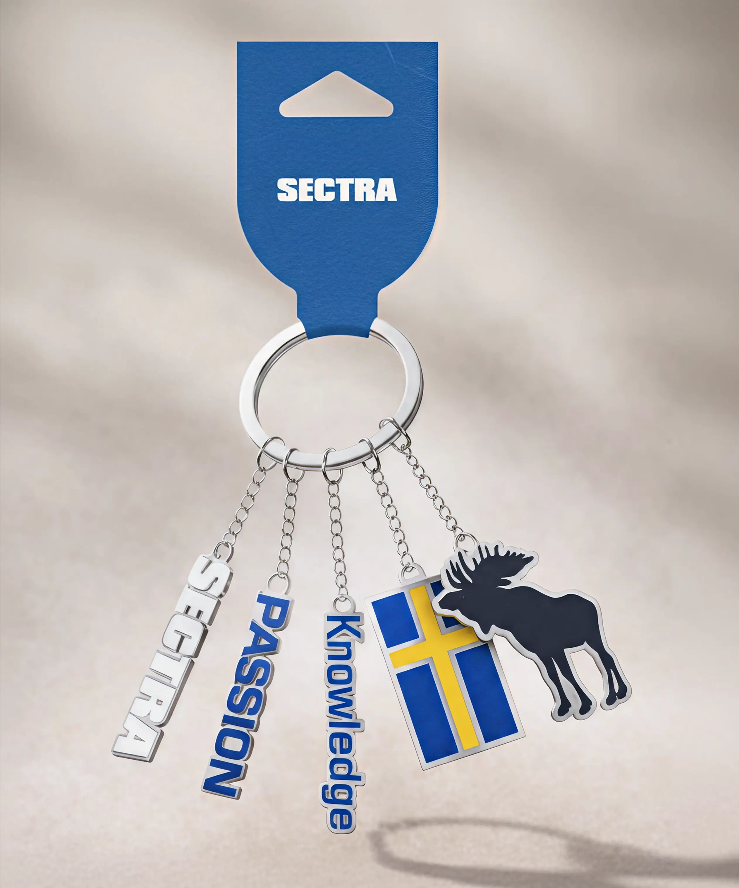 Sectra nyckelring med h&auml;ngen: logotyp, "Passion," "Knowledge," svensk flagga och &auml;lg.