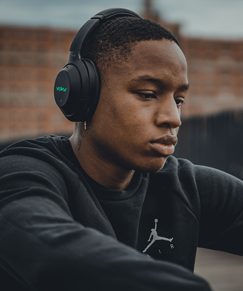 En ung man som lyssnar p&aring; musik med h&ouml;rlurar av m&auml;rket Voky
